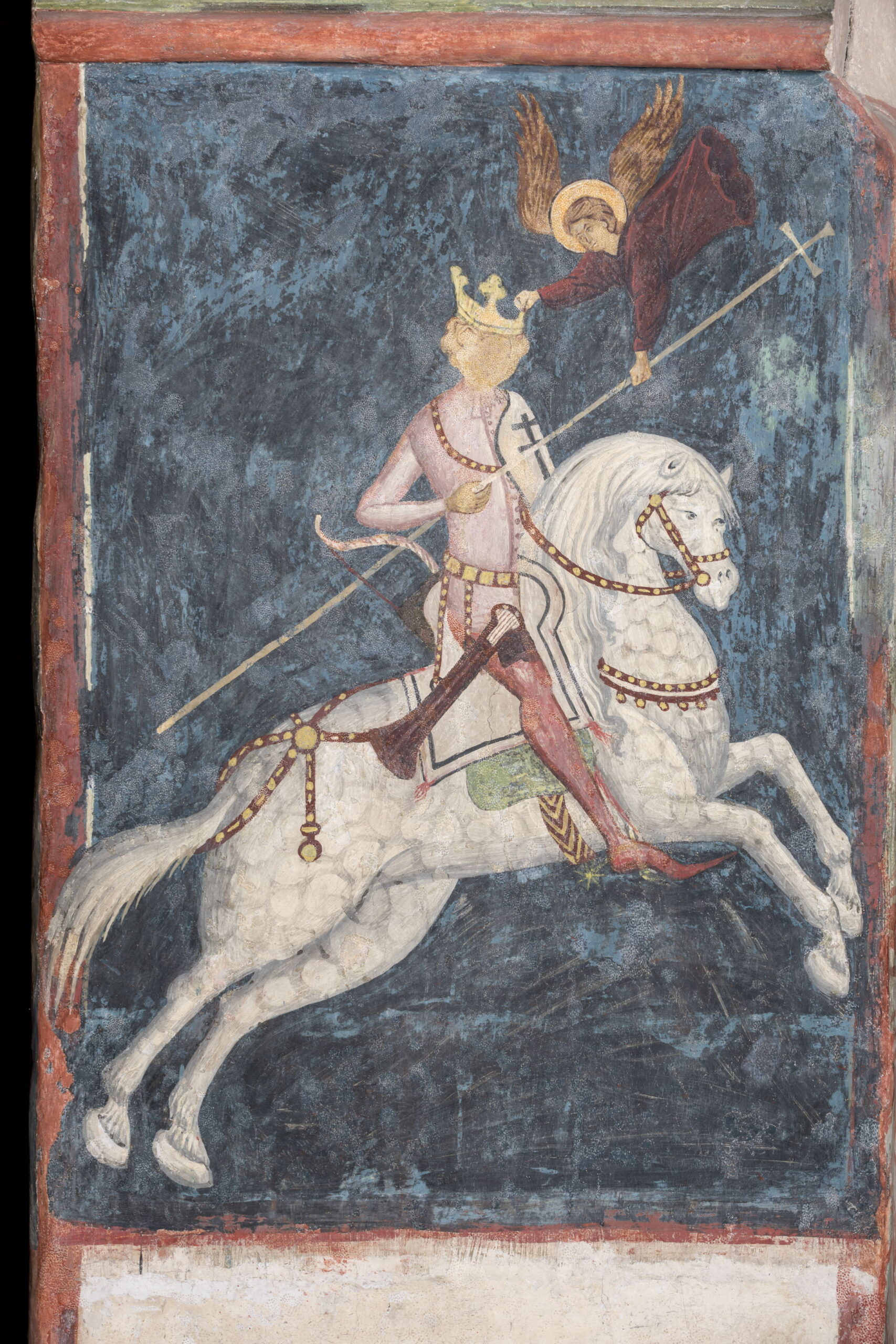 Fresk przedstawiający postać w koronie na białym koniu. Nad postacią anioł. Tło niebieskie.