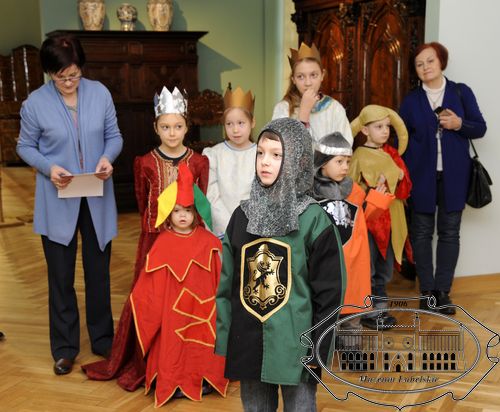 Grupa dzieci przebranych w średniowieczne stroje w czasie przedstawienia teatralnego