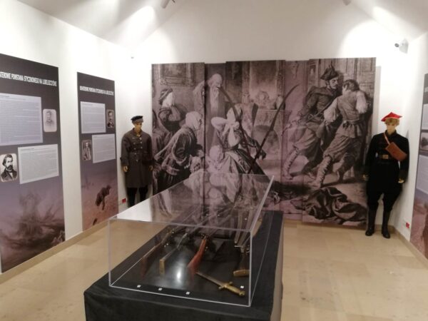 widok na sale wystawy, na środku gablota w rogach postacie zołnierzy na ścianach plansze